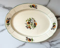 Vintage platter with a subtle scalloped edge and a delicate floral spray pattern.
